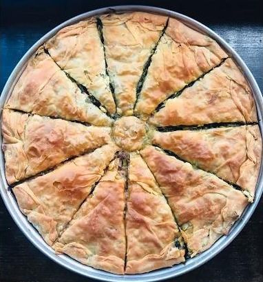 Whole homemade spanakopita cut into wedges